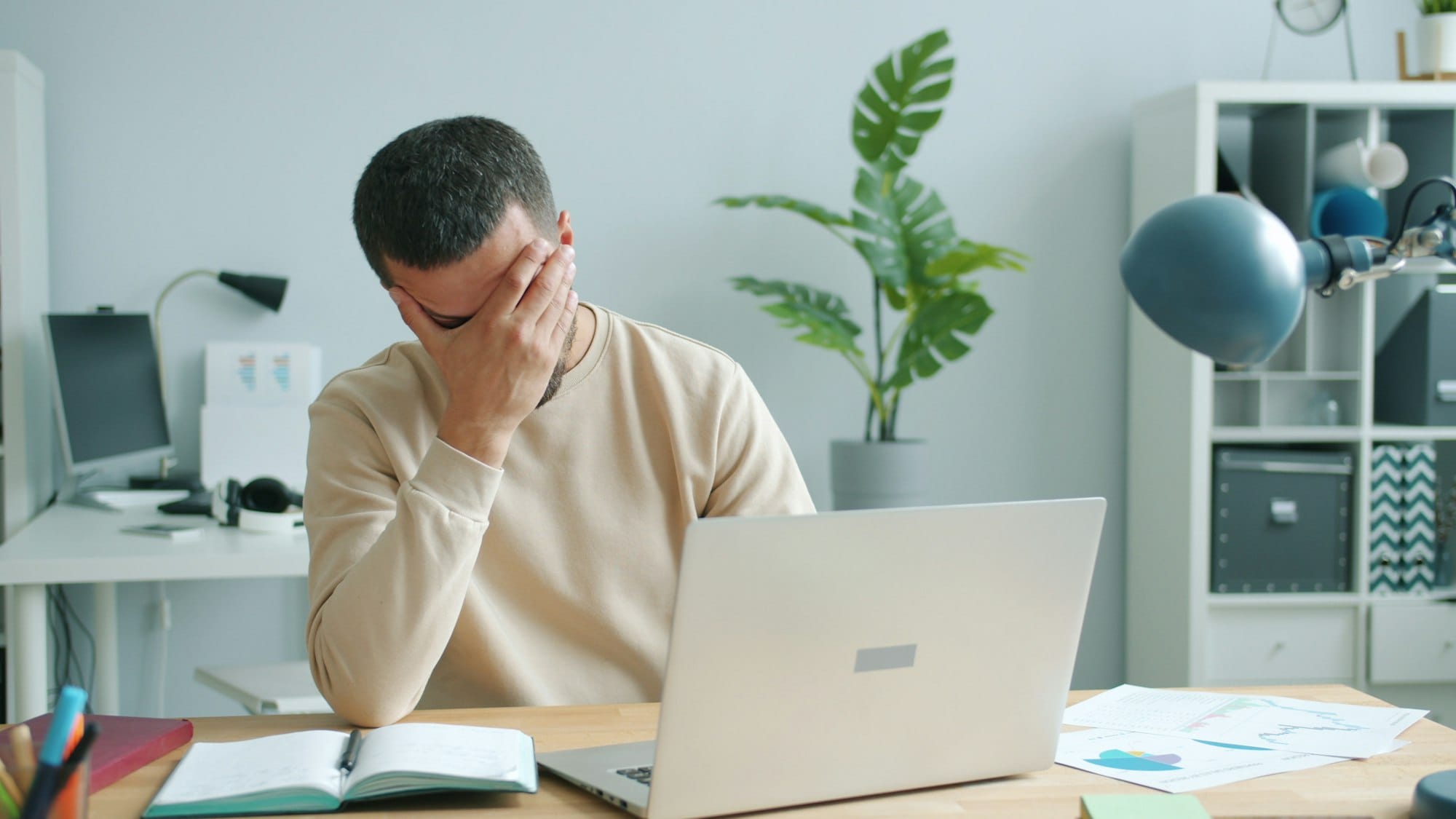 A man on his notebook facepalming, he probably reads about all these leaks